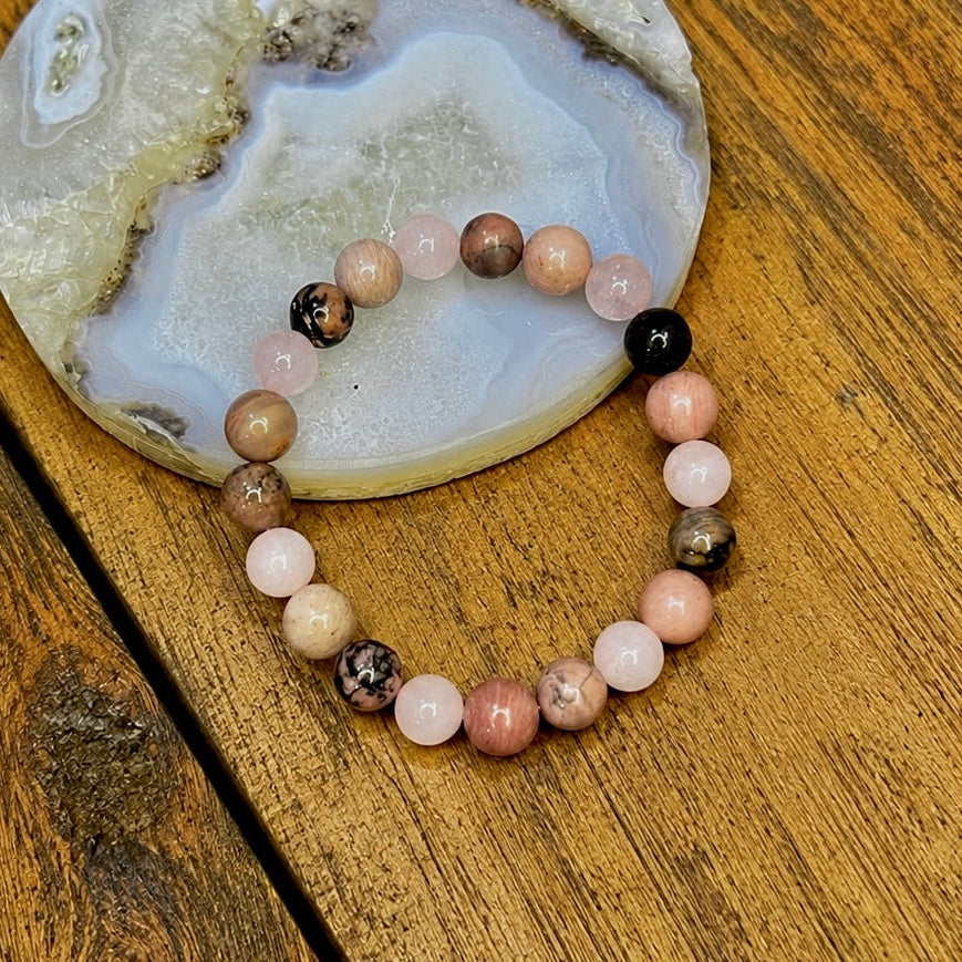 Beaded bracelet on a piece of agate stone on a wooden surface