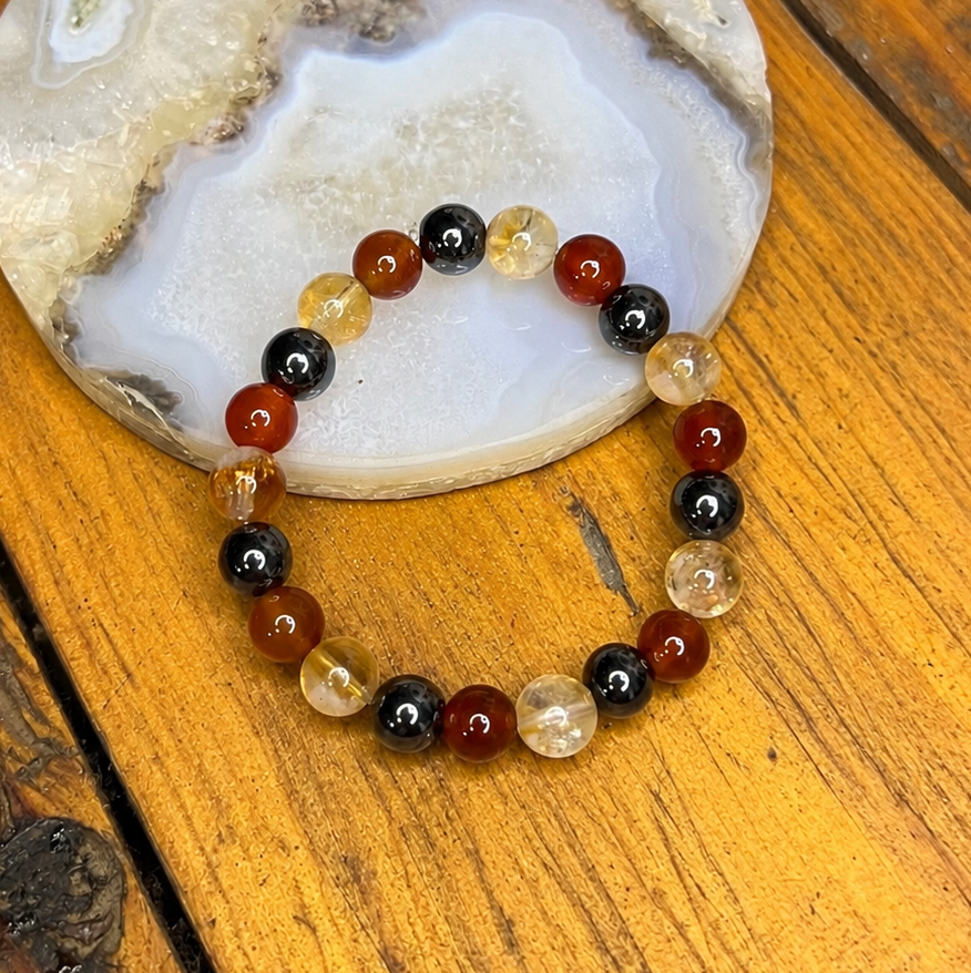 Multicolored beaded bracelet on a wooden surface with a stone background
