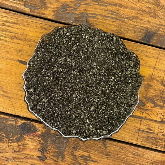 Round dark stone coaster on a wooden surface
